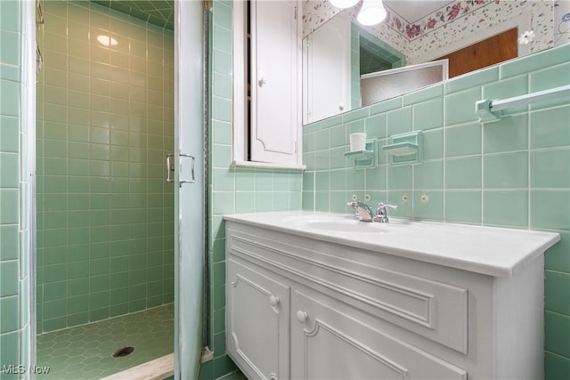 full bath featuring vanity, tile walls, tasteful backsplash, and a stall shower