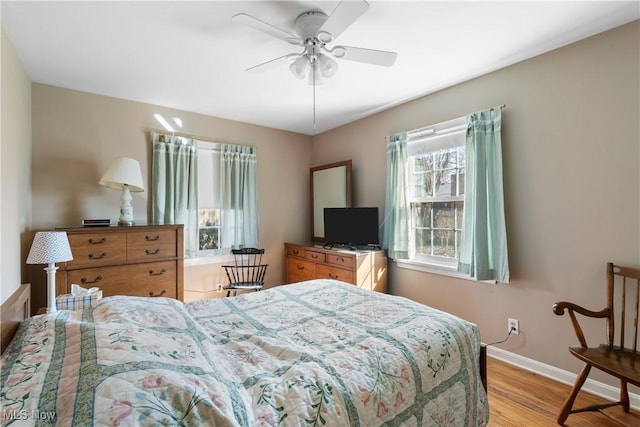 bedroom featuring ceiling fan, baseboards, and light wood-type flooring