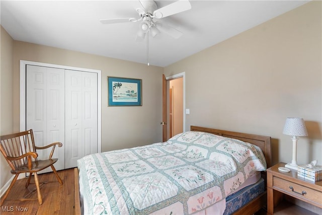 bedroom featuring a ceiling fan, wood finished floors, a closet, and baseboards