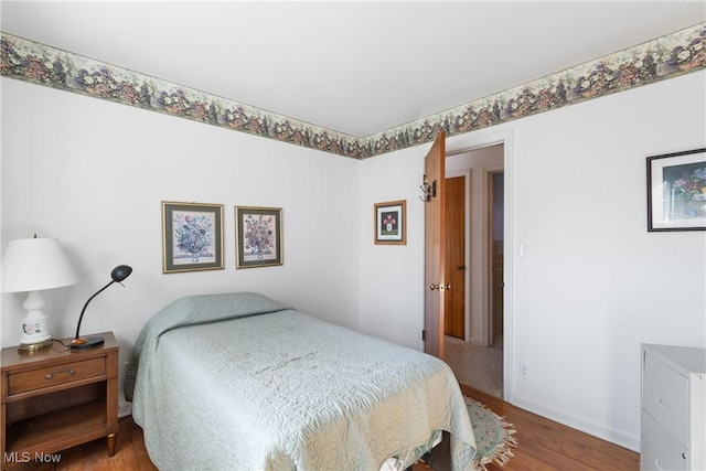 bedroom with wood finished floors and baseboards