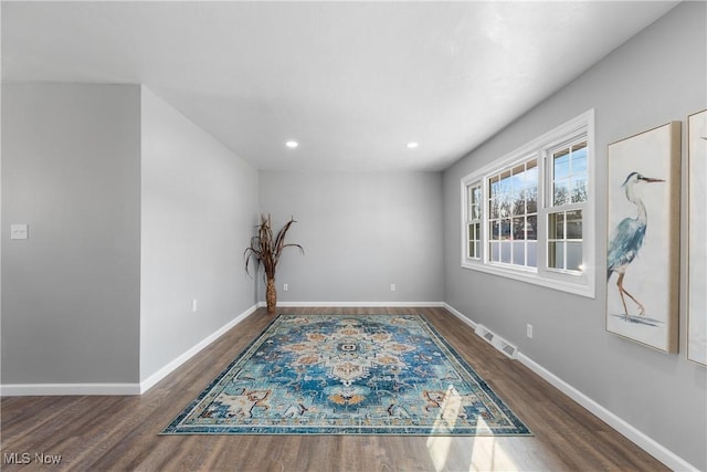 empty room with wood finished floors, recessed lighting, baseboards, and visible vents