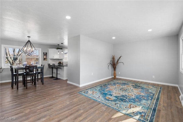 dining area featuring a notable chandelier, wood finished floors, and baseboards