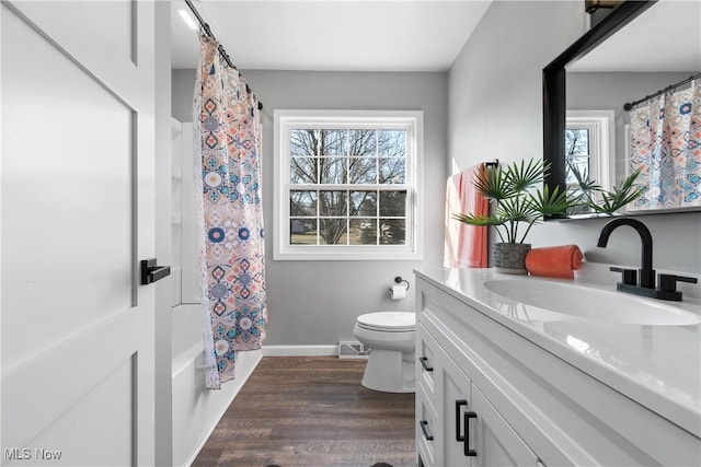 full bathroom featuring vanity, wood finished floors, visible vents, baseboards, and toilet