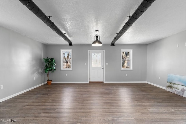 entryway featuring baseboards, a textured ceiling, and wood finished floors