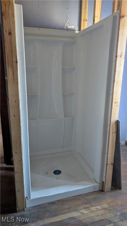 full bathroom featuring a shower stall and hardwood / wood-style floors