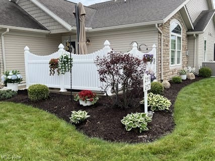 view of side of home with a yard and fence