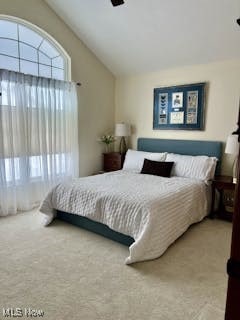 carpeted bedroom with lofted ceiling