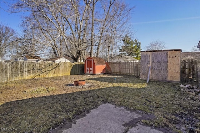 view of yard featuring an outbuilding, a storage unit, and a fenced backyard