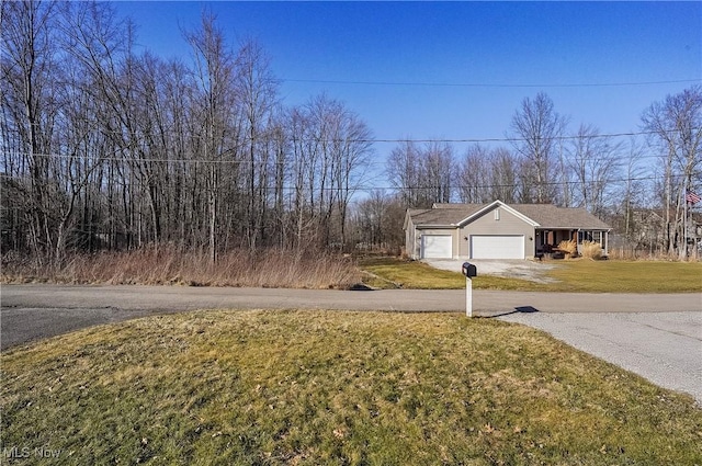 view of front of house featuring a garage, driveway, and a front yard