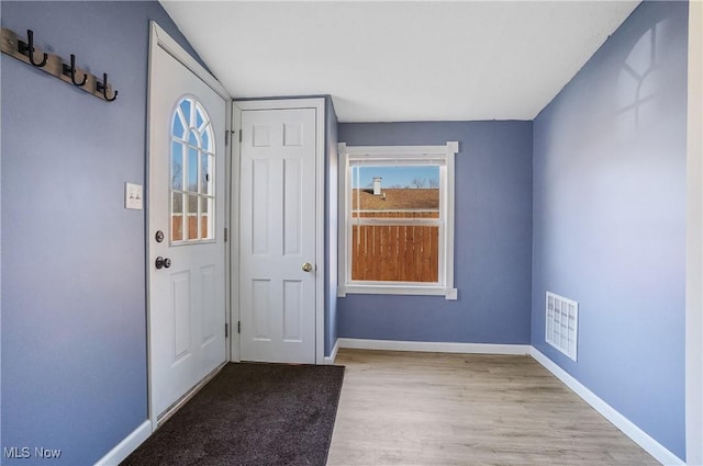 foyer featuring visible vents, baseboards, and wood finished floors