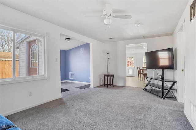 unfurnished living room featuring visible vents, baseboards, ceiling fan, and carpet floors