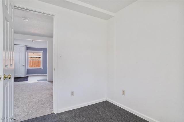 unfurnished room with baseboards and carpet