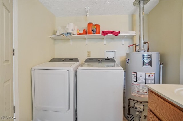 laundry area with gas water heater, a textured ceiling, laundry area, and washing machine and clothes dryer