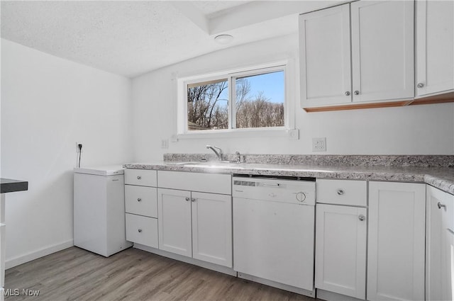 kitchen with a sink, dishwasher, and white cabinetry