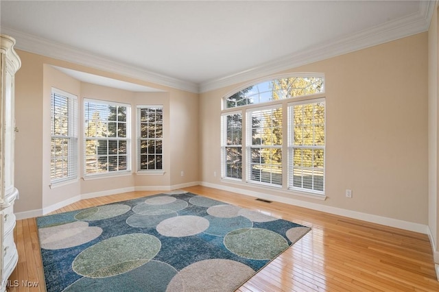 unfurnished room featuring a healthy amount of sunlight, baseboards, and wood-type flooring