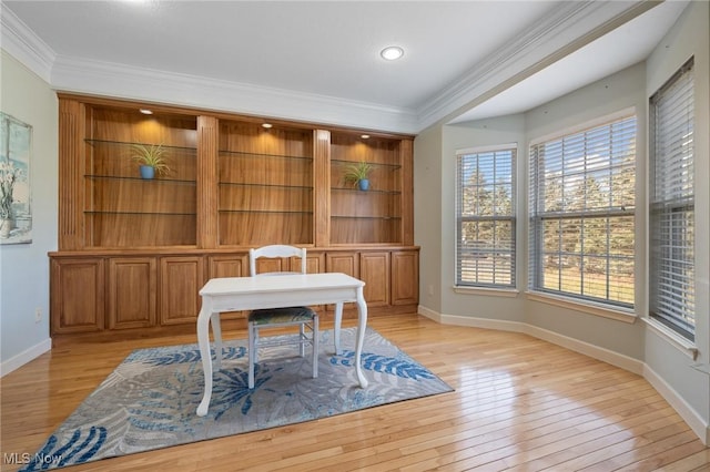 office space featuring baseboards, ornamental molding, and light wood finished floors