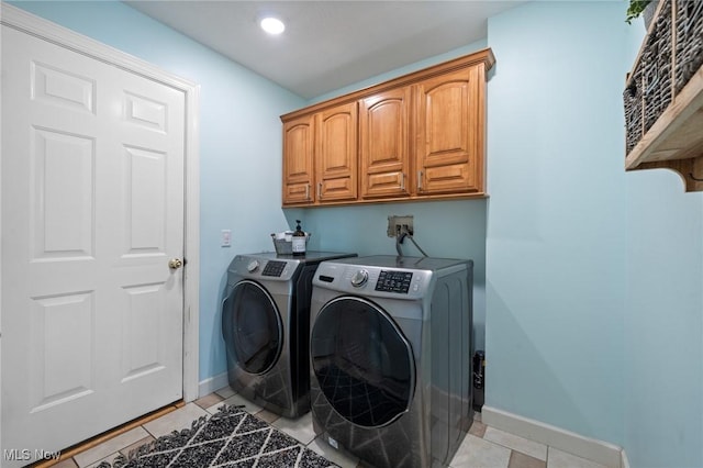 laundry room with light tile patterned flooring, cabinet space, independent washer and dryer, and baseboards