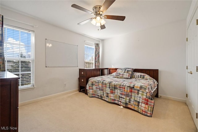 carpeted bedroom featuring ceiling fan and baseboards