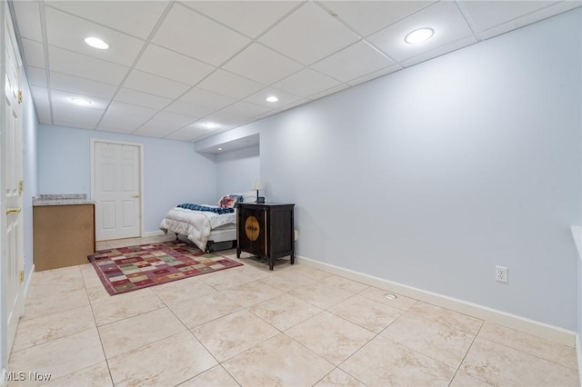 bedroom featuring light tile patterned floors, a drop ceiling, recessed lighting, and baseboards