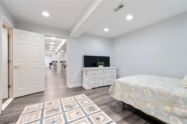 bedroom with recessed lighting, visible vents, baseboards, and wood finished floors