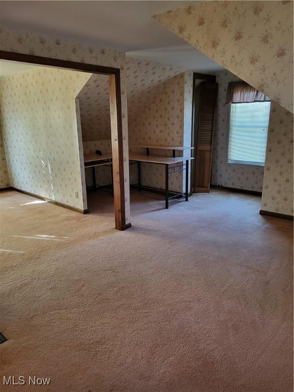 bonus room featuring wallpapered walls, carpet, and baseboards