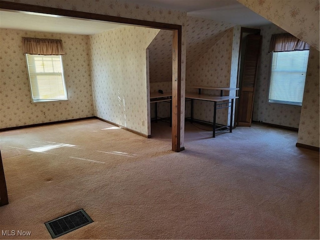 additional living space with visible vents, baseboards, carpet, and wallpapered walls