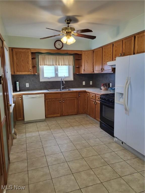 kitchen with a sink, white appliances, open shelves, and under cabinet range hood