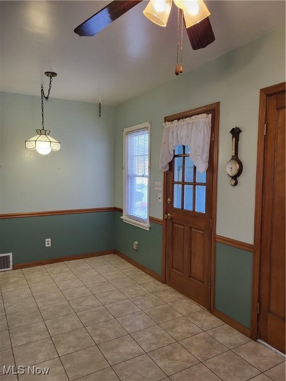 foyer entrance featuring light tile patterned floors, a ceiling fan, visible vents, and baseboards