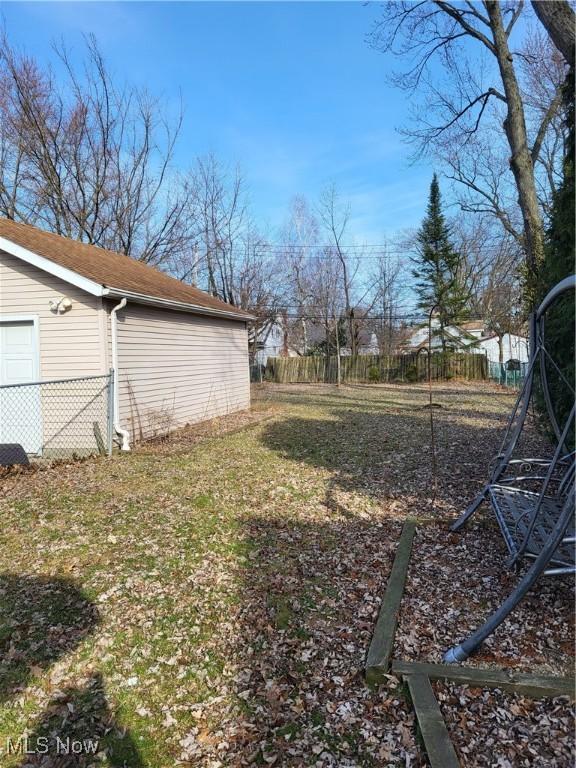 view of yard featuring fence and a garage