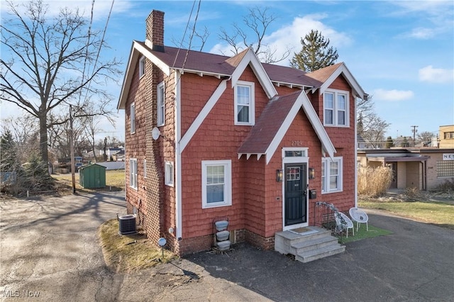 view of front of home featuring cooling unit and a chimney