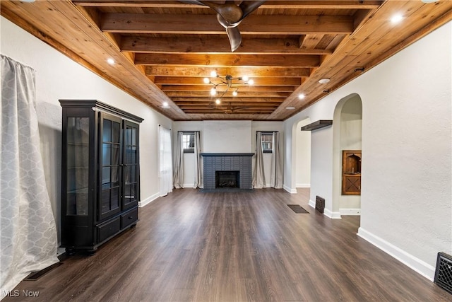 unfurnished living room featuring beam ceiling, arched walkways, wood ceiling, and dark wood-style floors