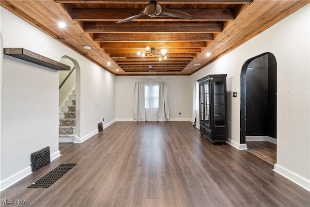 unfurnished living room featuring stairway, dark wood finished floors, beam ceiling, arched walkways, and wood ceiling