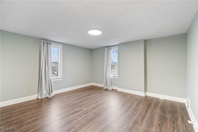 unfurnished room with baseboards and wood finished floors