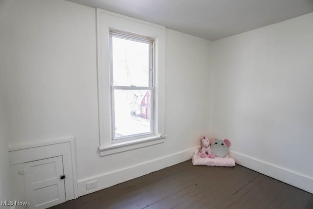 unfurnished room featuring baseboards and hardwood / wood-style flooring