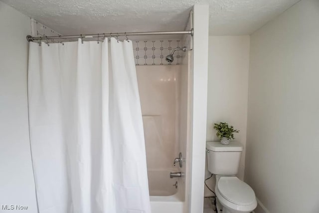 bathroom with toilet, shower / tub combo with curtain, and a textured ceiling