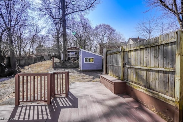 deck featuring a fenced backyard, a shed, and an outdoor structure