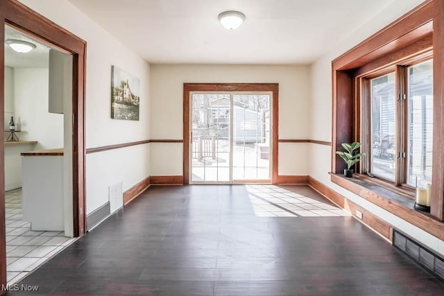 empty room with visible vents, baseboards, and wood finished floors