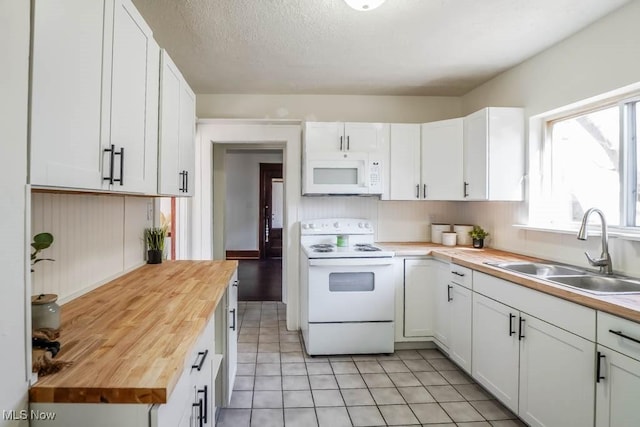 kitchen featuring a sink, a textured ceiling, white cabinetry, white appliances, and wooden counters