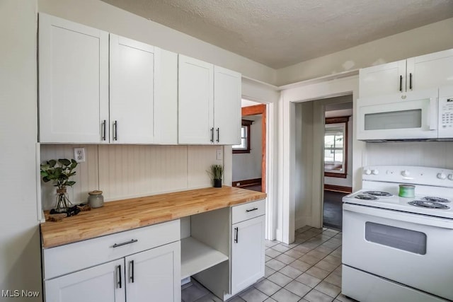 kitchen featuring butcher block countertops, white appliances, white cabinetry, and a textured ceiling