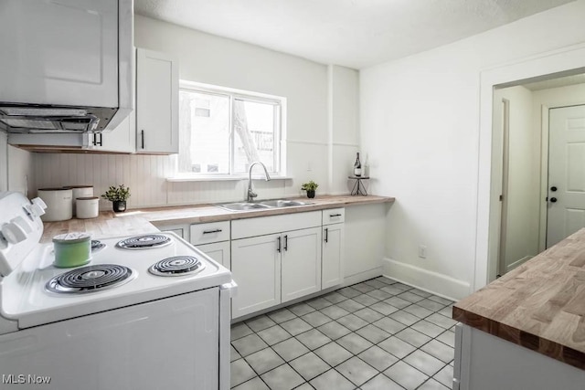 kitchen featuring butcher block counters, light tile patterned flooring, electric range, white cabinets, and a sink