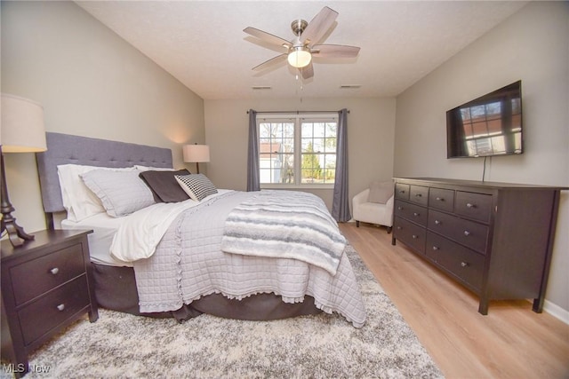 bedroom featuring visible vents, light wood-style floors, and ceiling fan