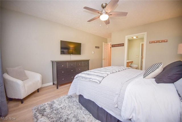 bedroom with baseboards, light wood-style flooring, ensuite bath, and ceiling fan