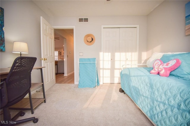 carpeted bedroom with visible vents and a closet