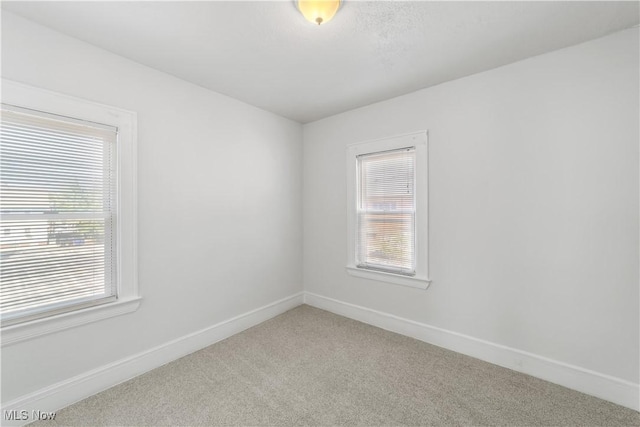 carpeted spare room with baseboards