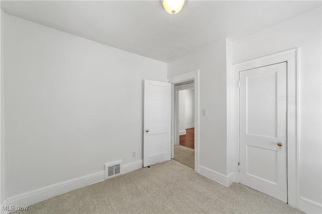 unfurnished bedroom featuring carpet, visible vents, and baseboards