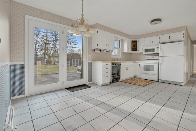 kitchen with pendant lighting, wallpapered walls, white appliances, white cabinets, and light countertops