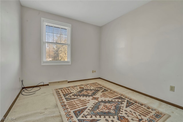 carpeted empty room featuring baseboards and baseboard heating