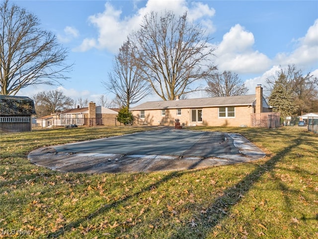 back of house featuring a yard, a chimney, and fence