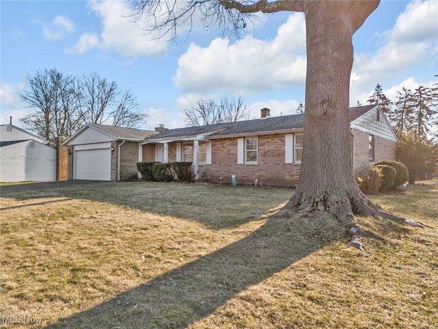 ranch-style home featuring a front lawn, an attached garage, brick siding, and a chimney