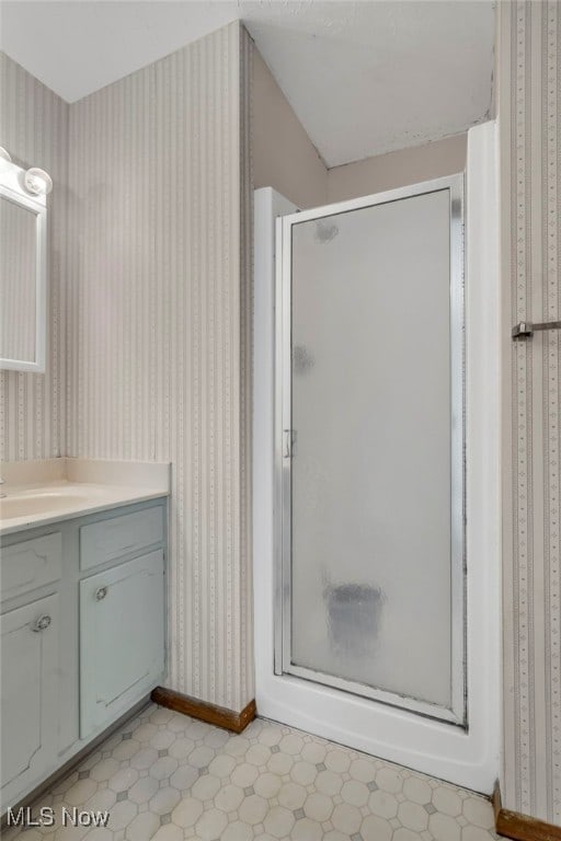 bathroom featuring tile patterned floors, a shower stall, wallpapered walls, and vanity